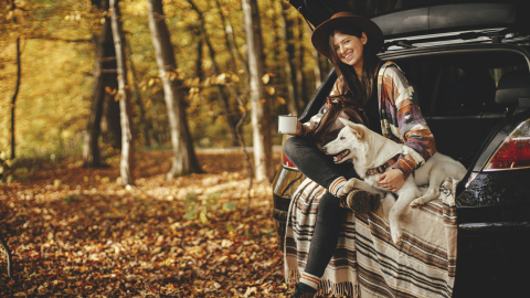 Herfstbeeld van vrouw met hond in het bos