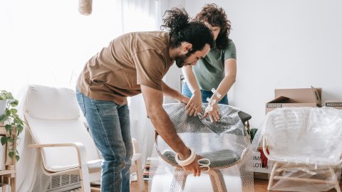 Déménagement en kot Dockx Les étudiants emballent des meubles avec du papier bulle pour un déménagement en toute sécurité